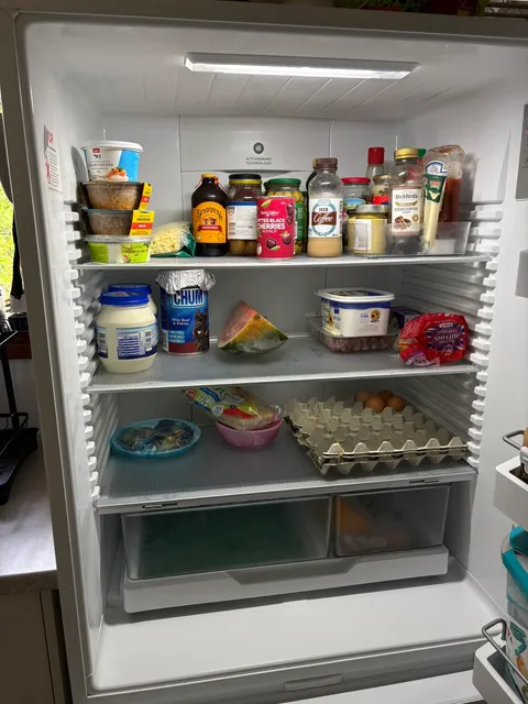 Fridge interior with shelves wiped and contents arranged neatly