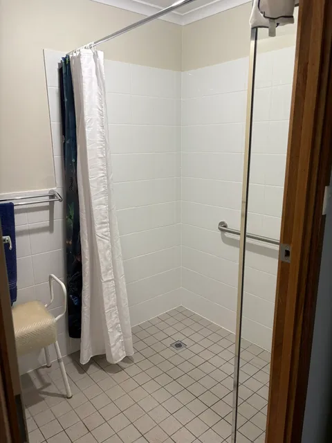 Shower recess with clean white tiles, grout and glass